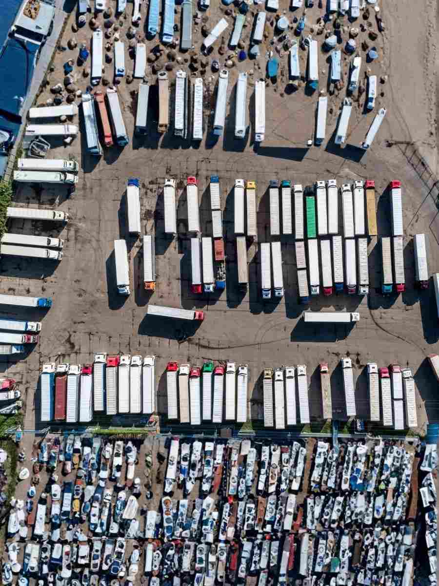 Aerial view of trucks and trailers parked in a large depot, representing fleet management and workplace road safety responsibilities.